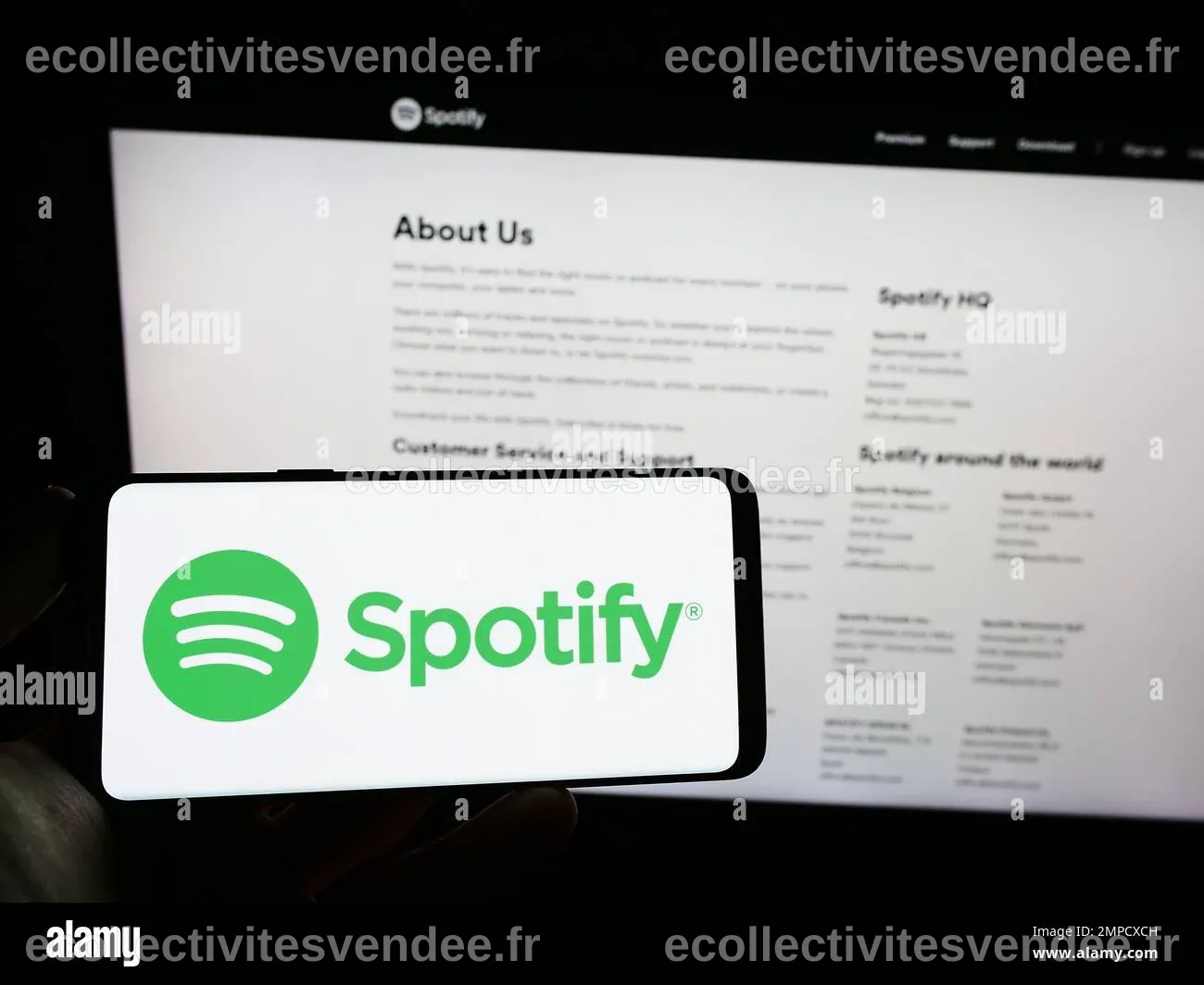 Person holding cellphone with logo of music streaming company Spotify ...