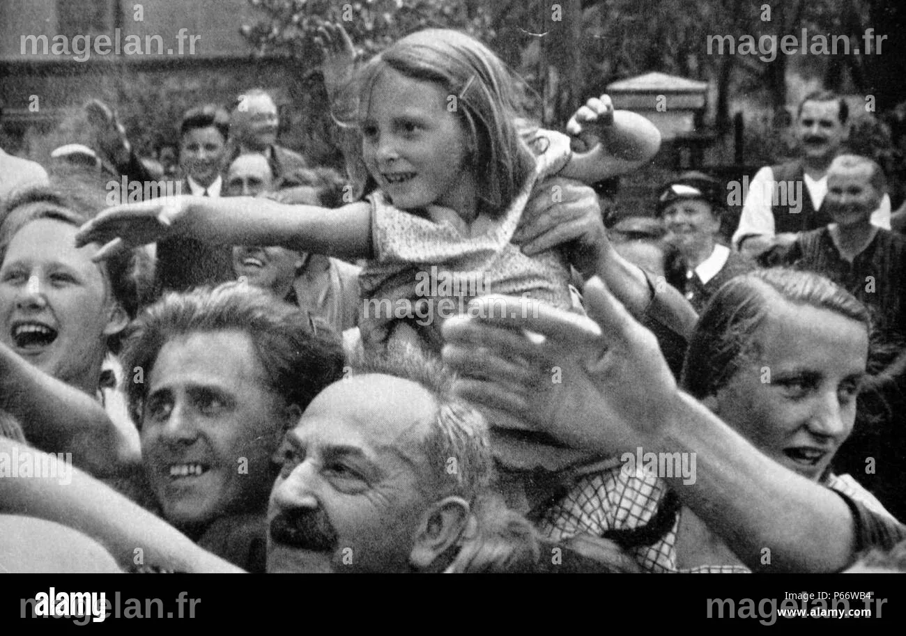 Une foule enthousiaste vague et saluer Adolf Hitler lors d'un défilé en ...