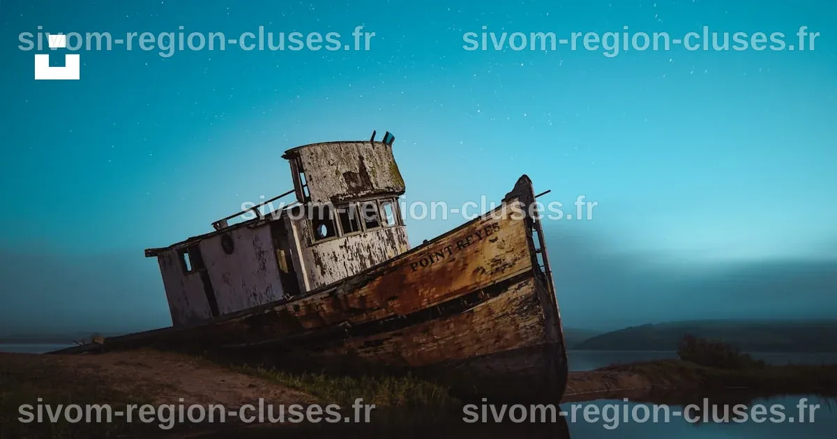 Navire abandonné sur le bord de la mer sous le ciel avec des étoiles ...
